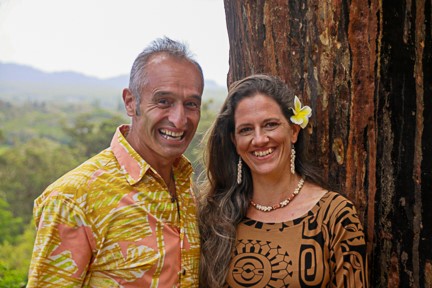 Ein Mann und eine Frau lächeln vor einem Baum.